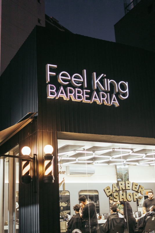 Fachada noturna da Feel King com letreiro iluminado