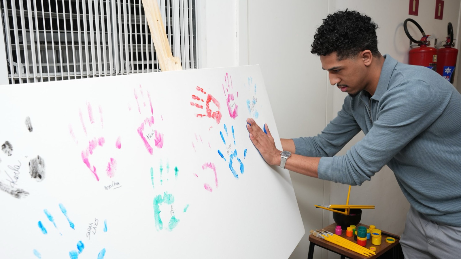 Colaborador deixando a marca da mão no painel coletivo da Fórmula Feel King
